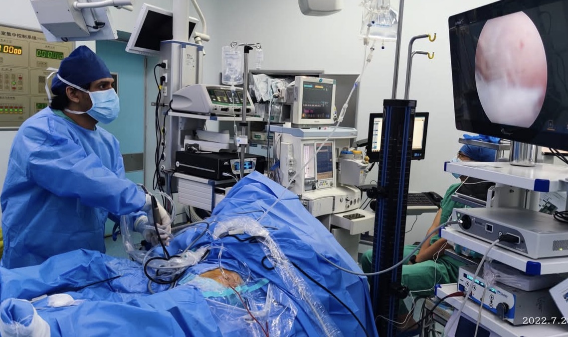 Dr. Sakurul Islam performing arthroscopic surgery in an operating theatre